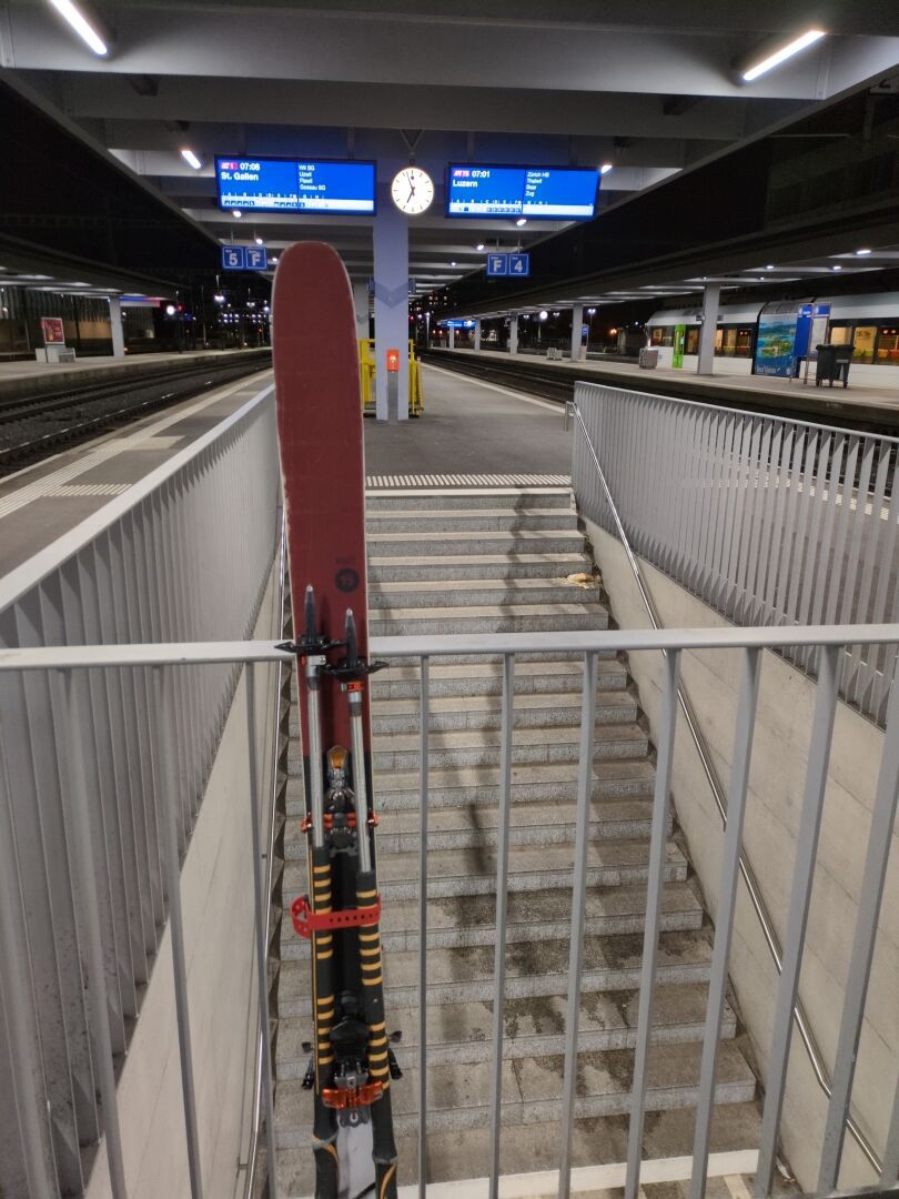 A pair of skis Leaning on a railing in a railway station